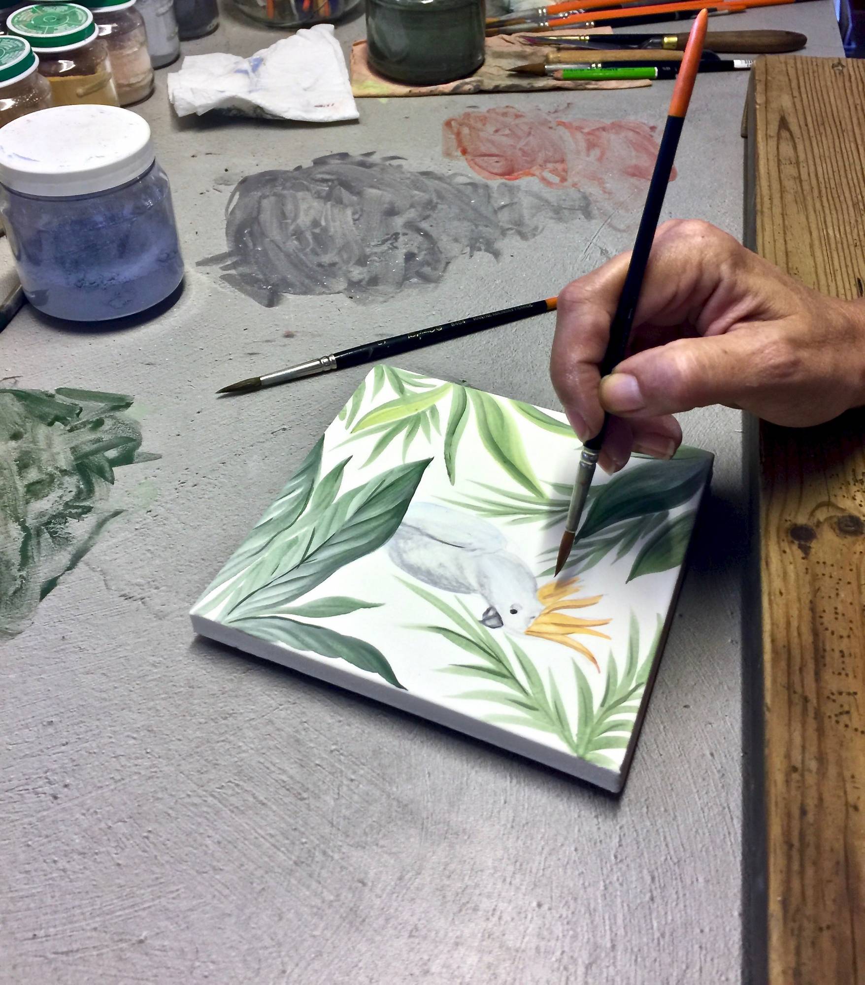 Peinture d'un carreau en terre de Salernes à la main en France par une de nos artistes céramistes